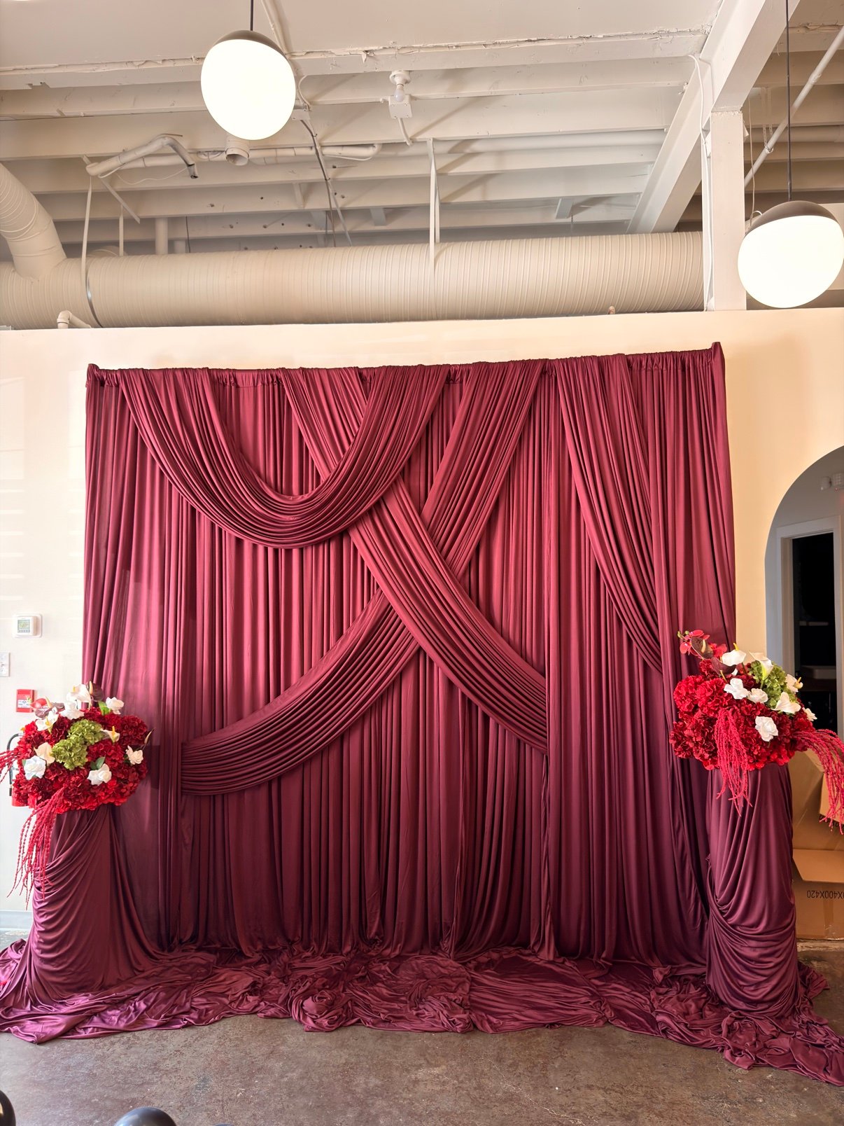 White draped backdrop with chandelier detail by Penbaga Events
