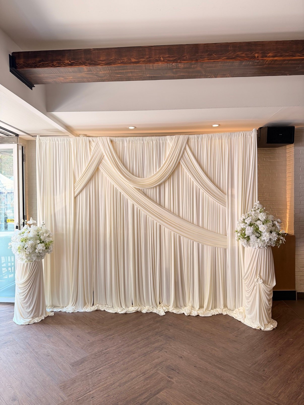 White draped fabric backdrop by Penbaga Events